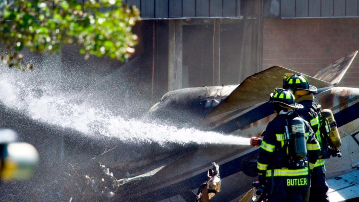 Firefighters spray water at the scene of a plane crash, in Farmington, Connecticut. — AP