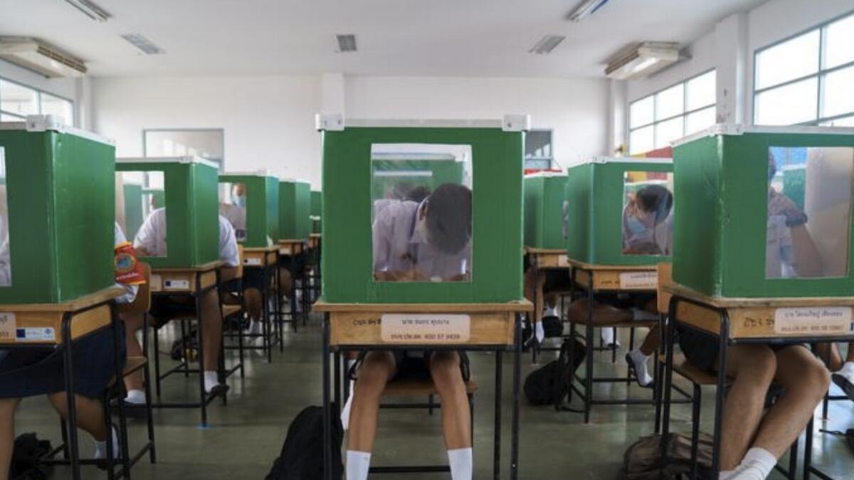 Students sit behind old ballot boxes re-purposed into partitions as they attend class in Pathum Thani province, Thailand. Reuters