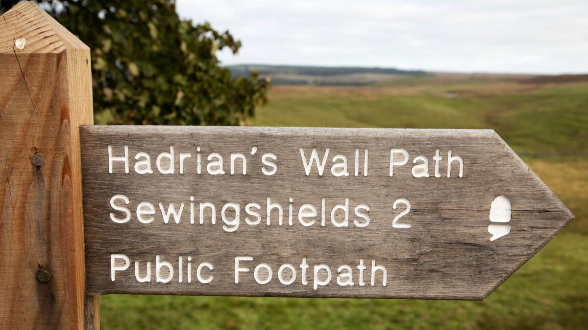 Sign on Hadrian's Wall Path in Northumberland, England. The public footpath runs 2 miles to Sewingshields.