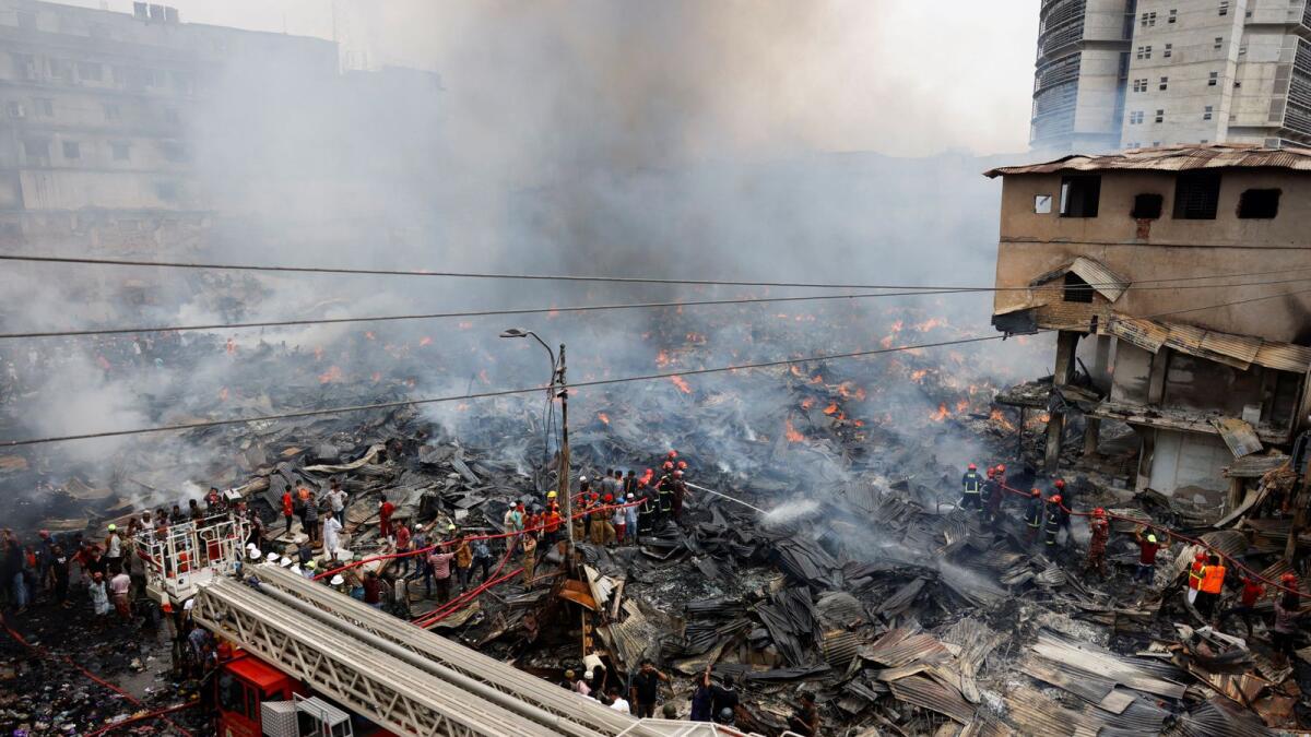 Firefighters try to douse a fire that broke out in a clothing market in Dhaka, Bangladesh, on Tuesday. -- Reuters