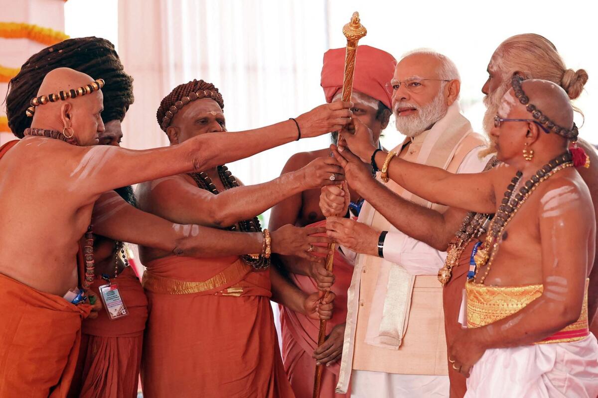 India's Prime Minister Narendra Modi holding the Sengol, a Tamil sceptre along with priests during the inauguration ceremony of the new parliament building in New Delhi on Sunday. Photo: AFP