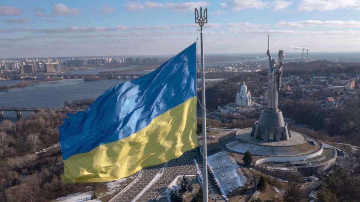 A view of Ukraine's national flag waves above the capital with the Motherland Monument on the right, in Kyiv. — AP