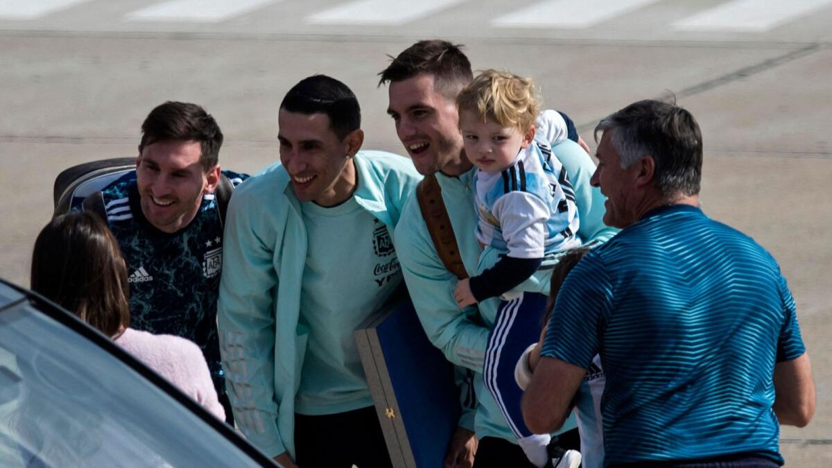 Argentina's (left to right) Lionel Messi, Angel Di Maria and Giovani Lo Celso -holding his son- speak with Lionel Messi's wife Antonella Roccuzzo upon their arrival at the Islas Malvinas airport in Rosario, Santa Fe province, Argentina. — AFP