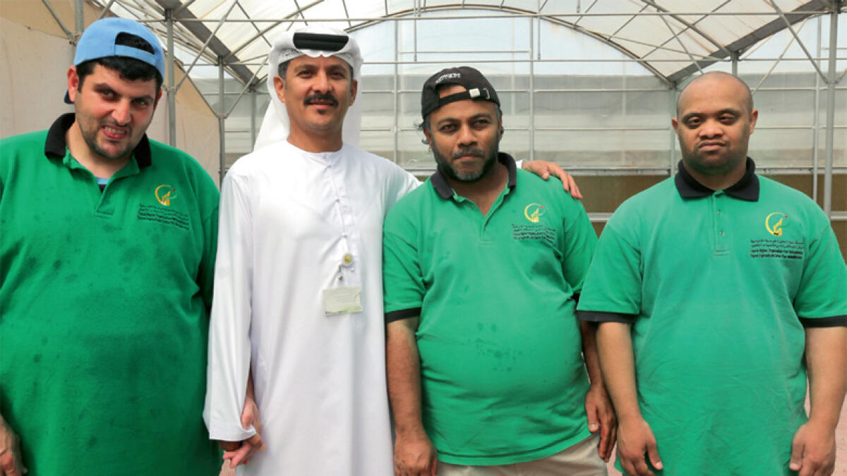 Abdulla Al Hashmi (second from left), public relations and marketing officer for the Centre, with farm workers.