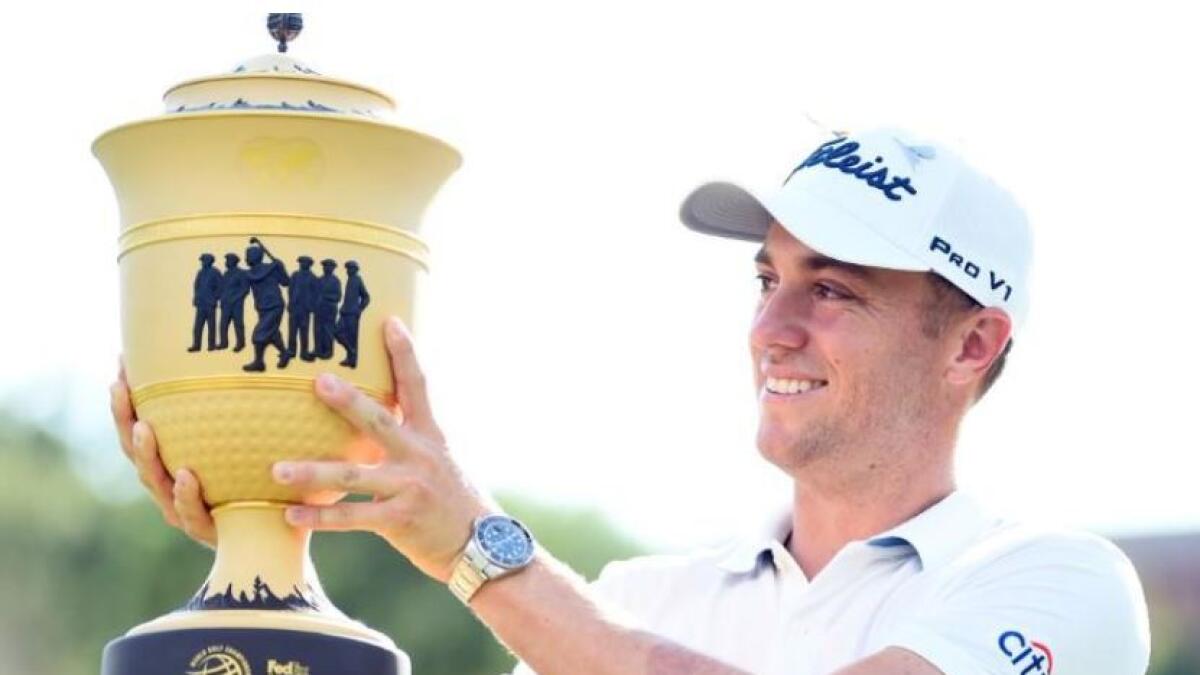 Justin Thomas poses with the World Golf Championships trophy. (Reuters)