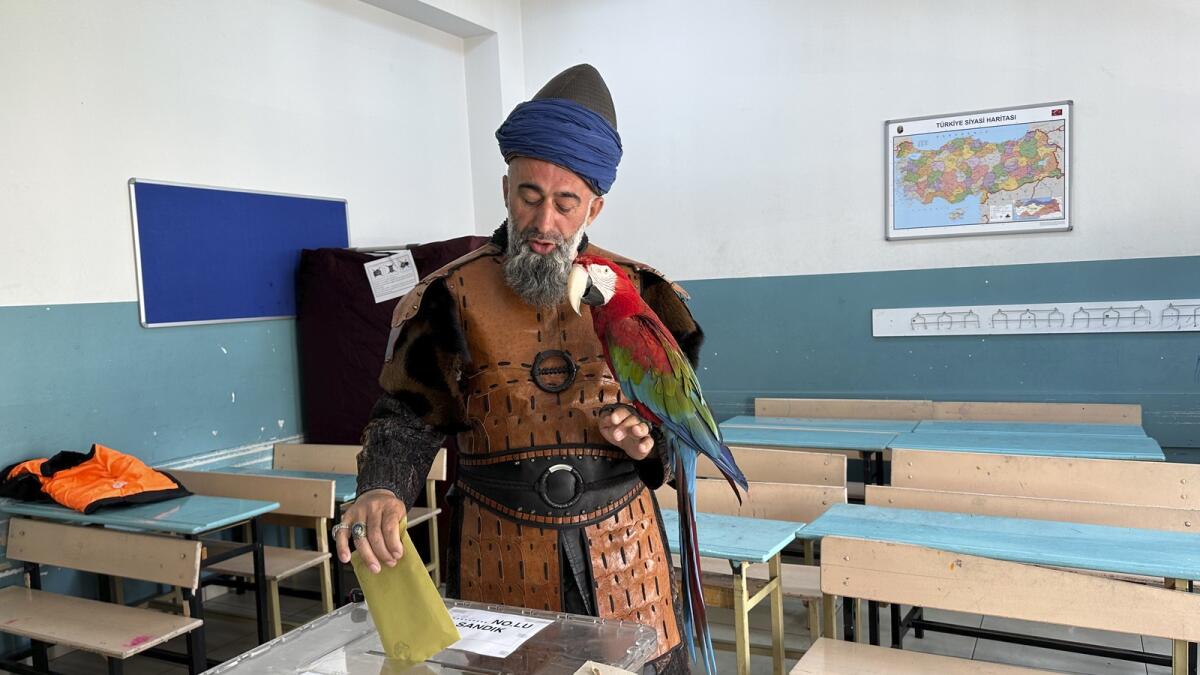 Nazim Cihan, 48, holds his bird as he votes at a polling station in Istanbul.
