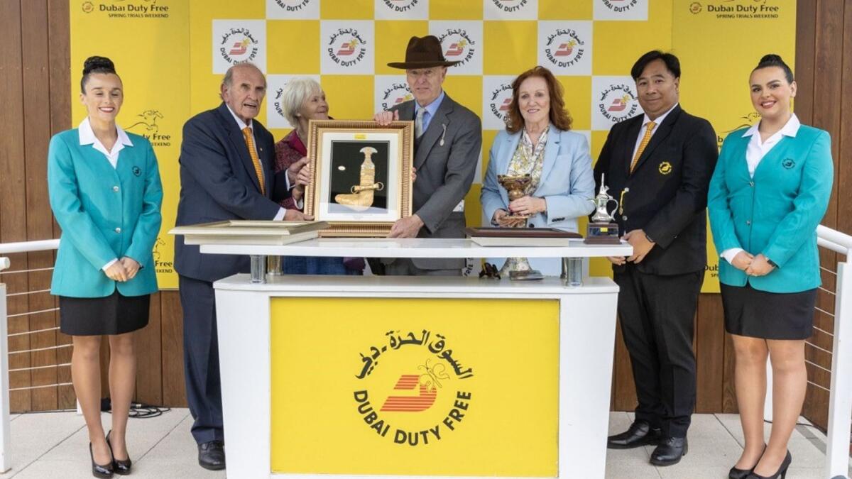 Remarquee Owner Julian Richmond-Watson, accompanied by his wife, receives the trophy for the Dubai Duty Free Stakes from  Colm McLoughlin and  Sinead El Sibai, alongside Dubai Duty Free staff - Supplied photo file