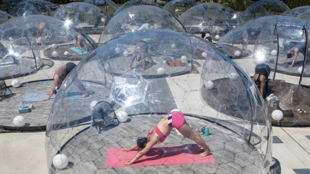 People participate in an outdoor yoga class in a dome to facilitate social distancing, in Toronto, Canada. - Reuters