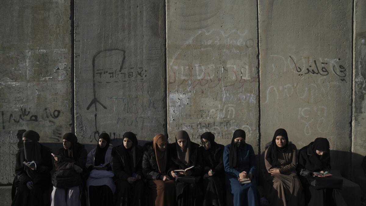 Palestinian women wait to cross the Israeli military Qalandia checkpoint near the West Bank city of Ramallah to Jerusalem, to participate in Friday prayers at Al Aqsa Mosque compound. — AP