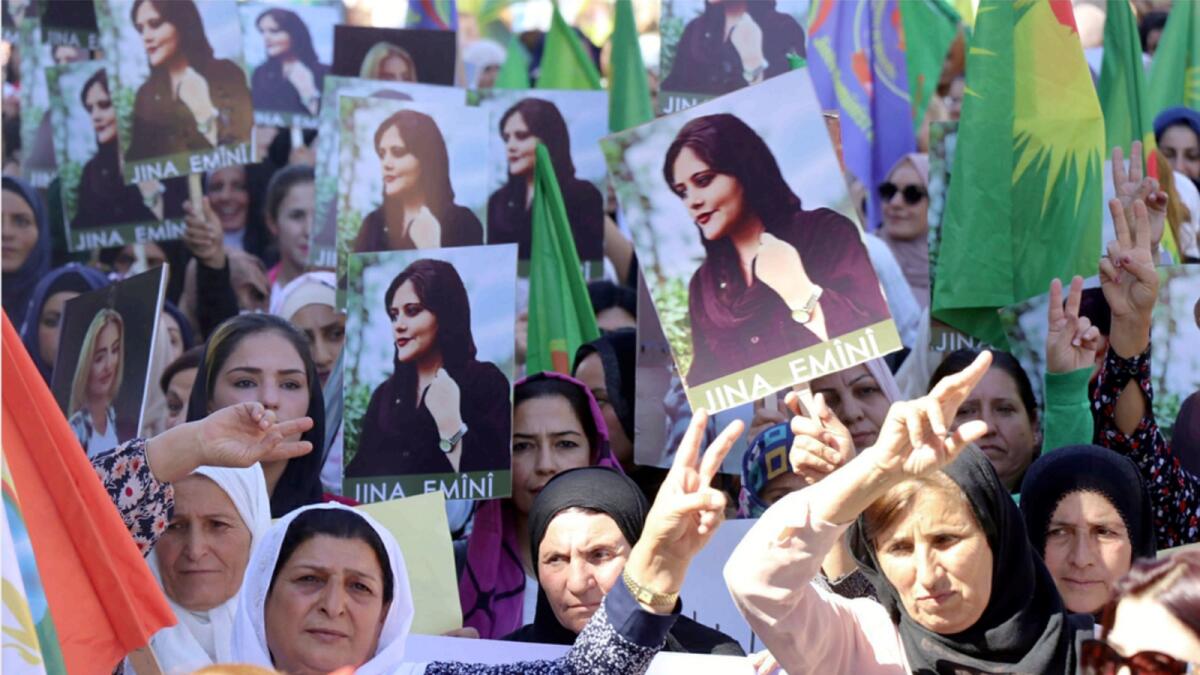 Kurdish women hold portraits of Mahsa Amini, during a protest in the city of Qamishli, northern Syria. — AP