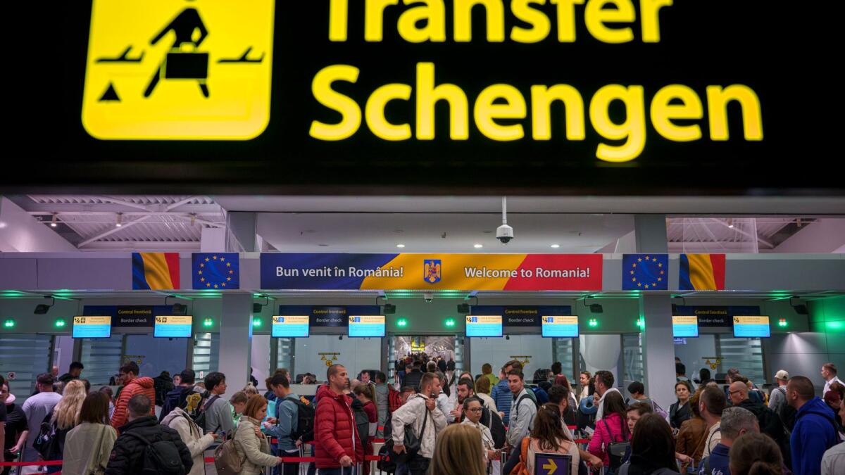Passengers arriving at the Henri Coanda International Airport pass under a Schengen Information sign, in Otopeni, near Bucharest, Romania, Sunday, March 31, 2024. — AP