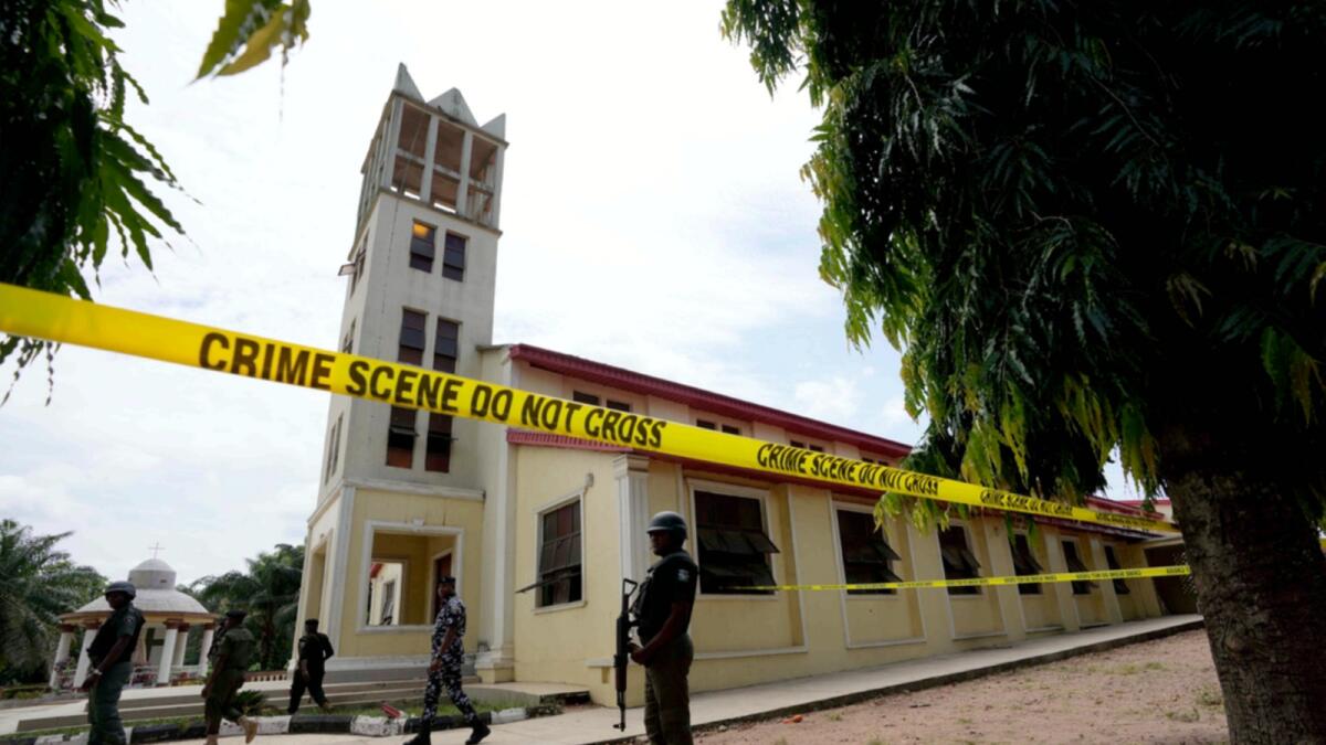 Nigerian police stand guard outside of the St. Francis Catholic church in Owo, Nigeria. — AP