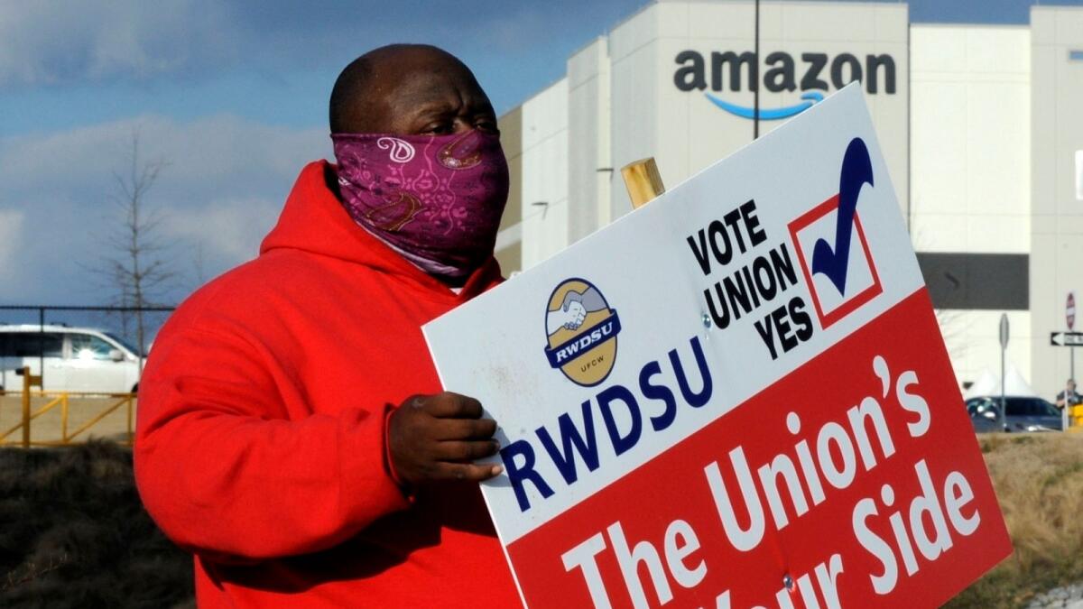 Michael Foster of the Retail, Wholesale and Department Store Union holds a sign outside an Amazon facility where labour is trying to organise workers in Bessemer, Alaska. When Amazon found out that workers were trying to form a union, a worker said that the company put up signs across the warehouse in Bessemer, Alaska, including in bathroom stalls. — AP file