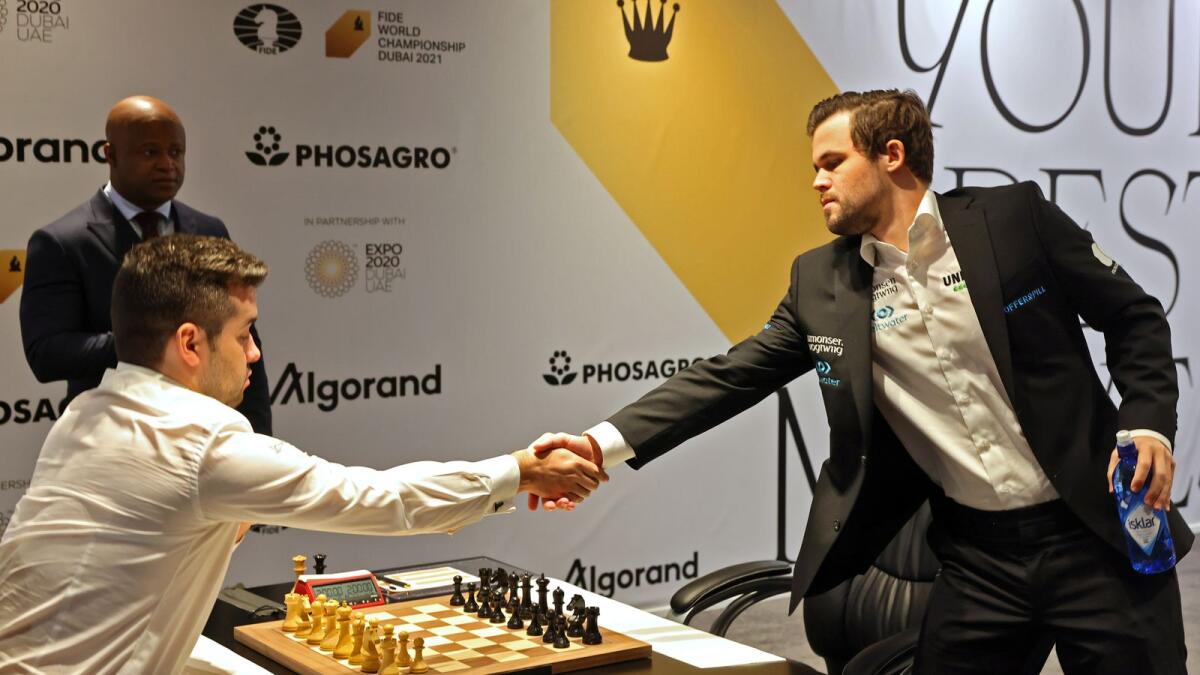 Magnus Carlsen (right) won a gripping battle against Ian Nepomniachtchi to clinch the world chess title in Dubai. (AFP)