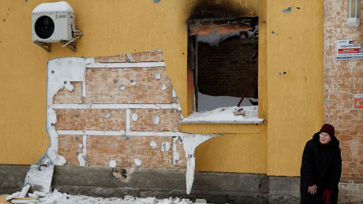 A woman walks next to a wall of a building from which a group of people tried to steal the work of street artist Banksy in the town of Hostomel, Kyiv region, on Saturday. — Reuters