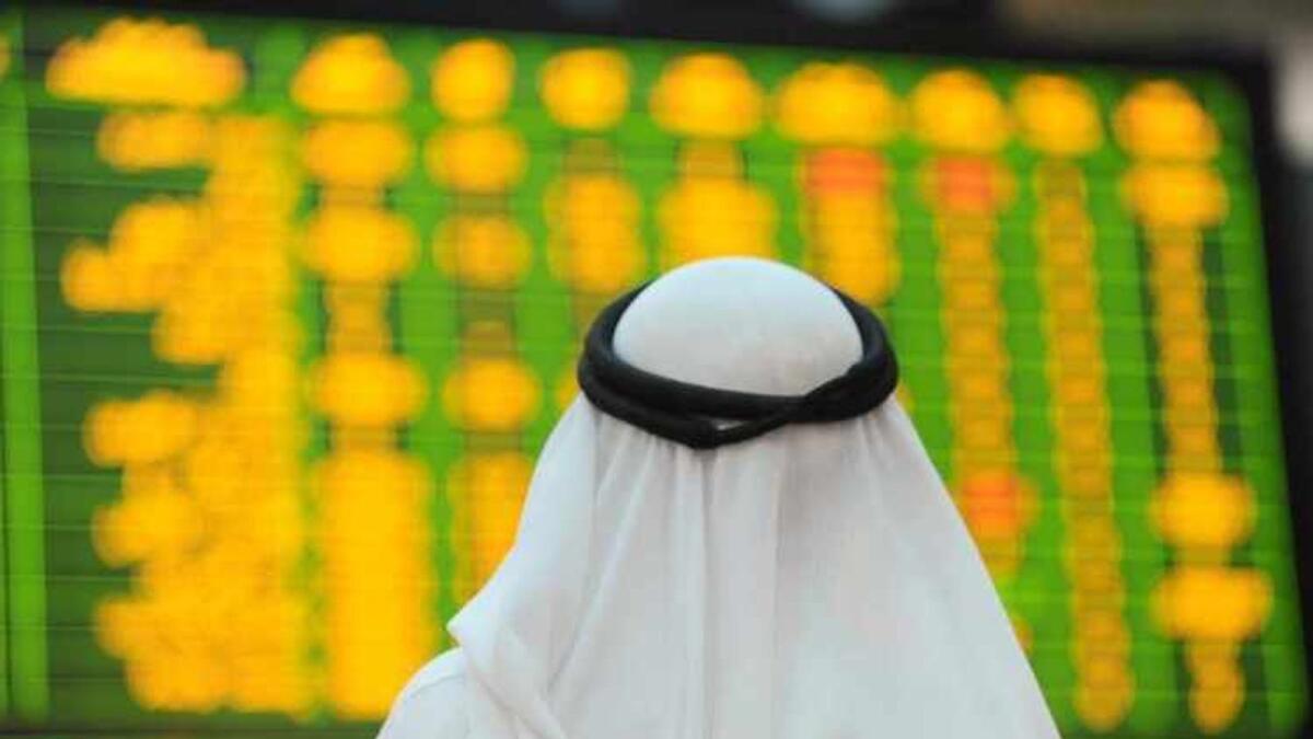 An investor looks up at electronic boards displaying stock information at the Abu Dhabi Securities Exchange stock market. The exchange’s market capitalisation further climbed to Dh1.85 trillion on Monday, according to the ADX website. — Reuters file photo