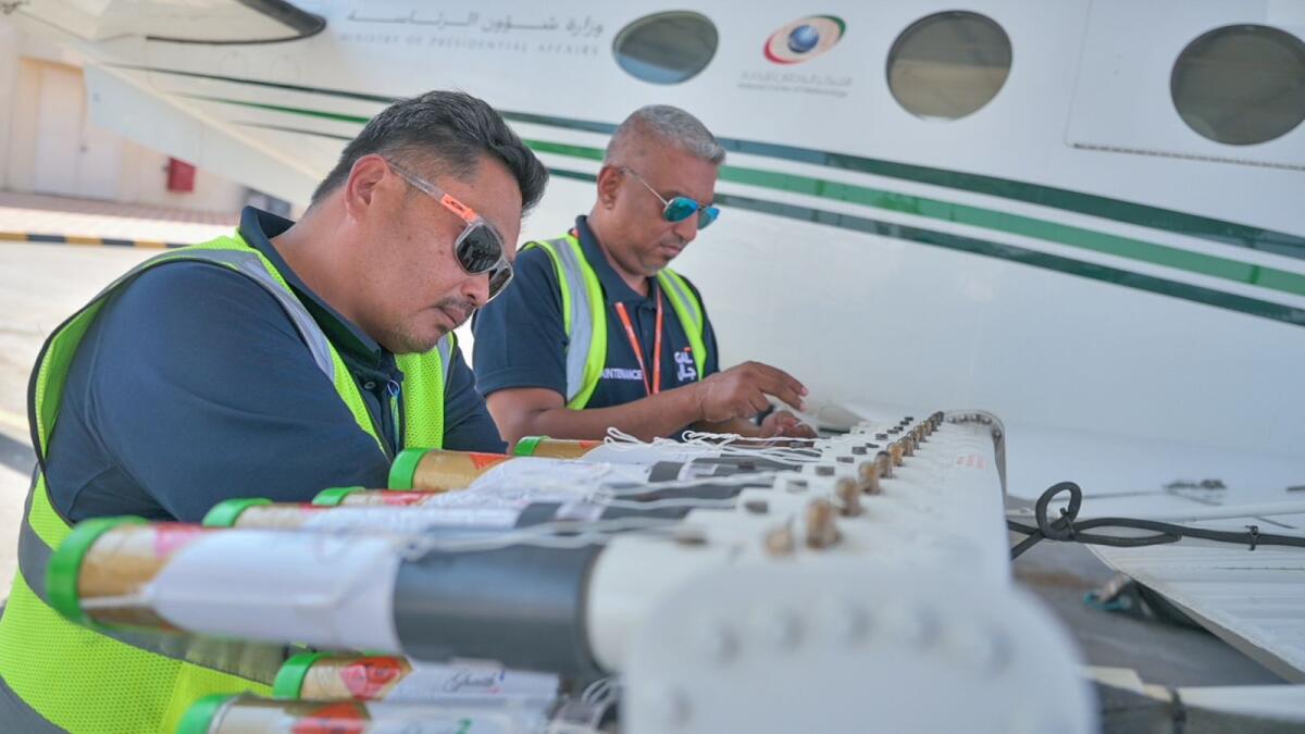 FILE. Technician attaching Hygroscopic (water-attracting) salt flares to an aircraft at Al Ain International Airport before a cloud-seeding on Oct 12, 2023. KT Photo: Rahul Gajjar