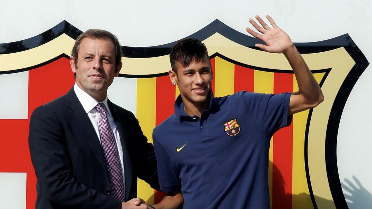 Brazilian Neymar (right) shakes hands with Barcelona's then president Sandro Rosell after signing a five-year contract with FC Barcelona in June 3, 2013. - Reuters file