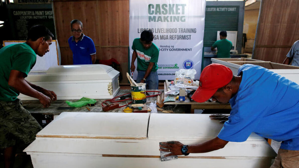 Drug users in the Philippines making coffins during rehab