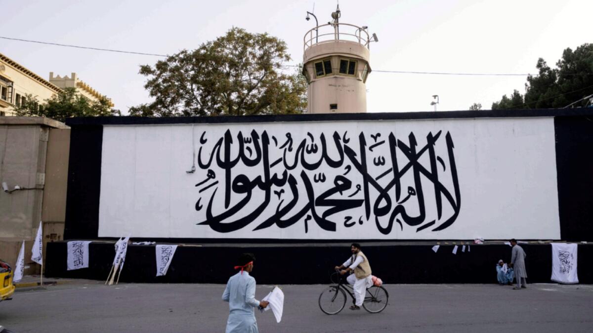 The iconic Taliban flag is painted on a wall outside the American embassy compound in Kabul. — AP