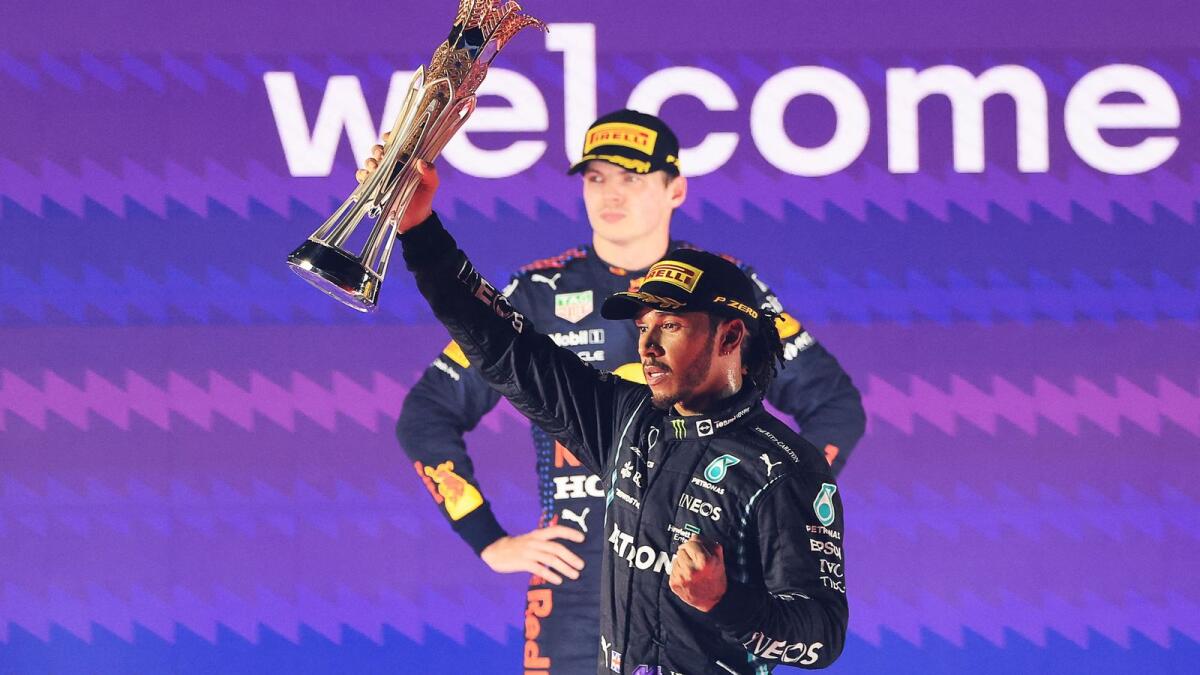 Lewis Hamilton (right) celebrates after winning the Saudi Arabian Grand Prix while title rival Max Verstappen looks on. — AFP