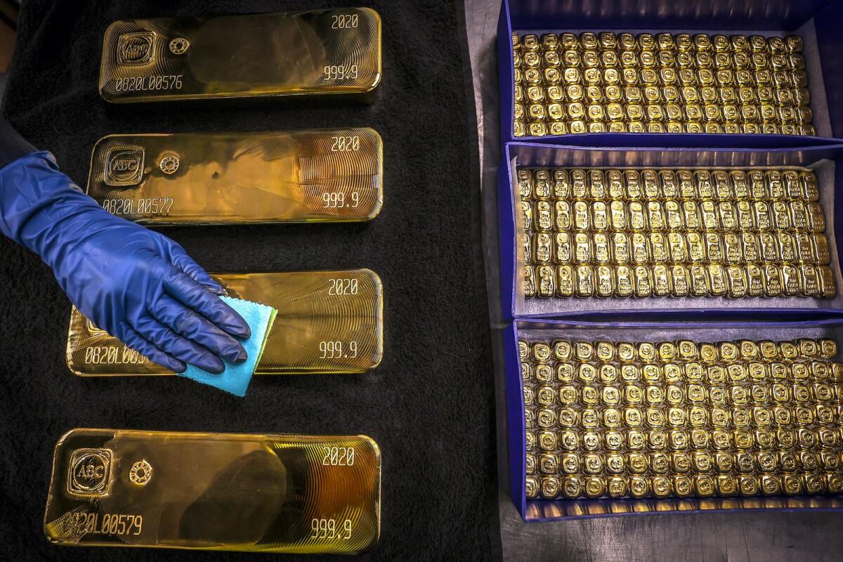 A worker polishes gold bullion bars at the ABC Refinery in Sydney. — AFP
