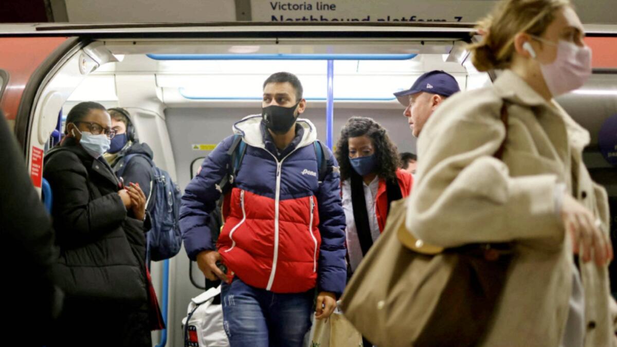Commuters, some wearing face coverings to mitigate the spread of Covid-19, exit a Transport for London (TfL) underground train carriage in cental London. — AFP