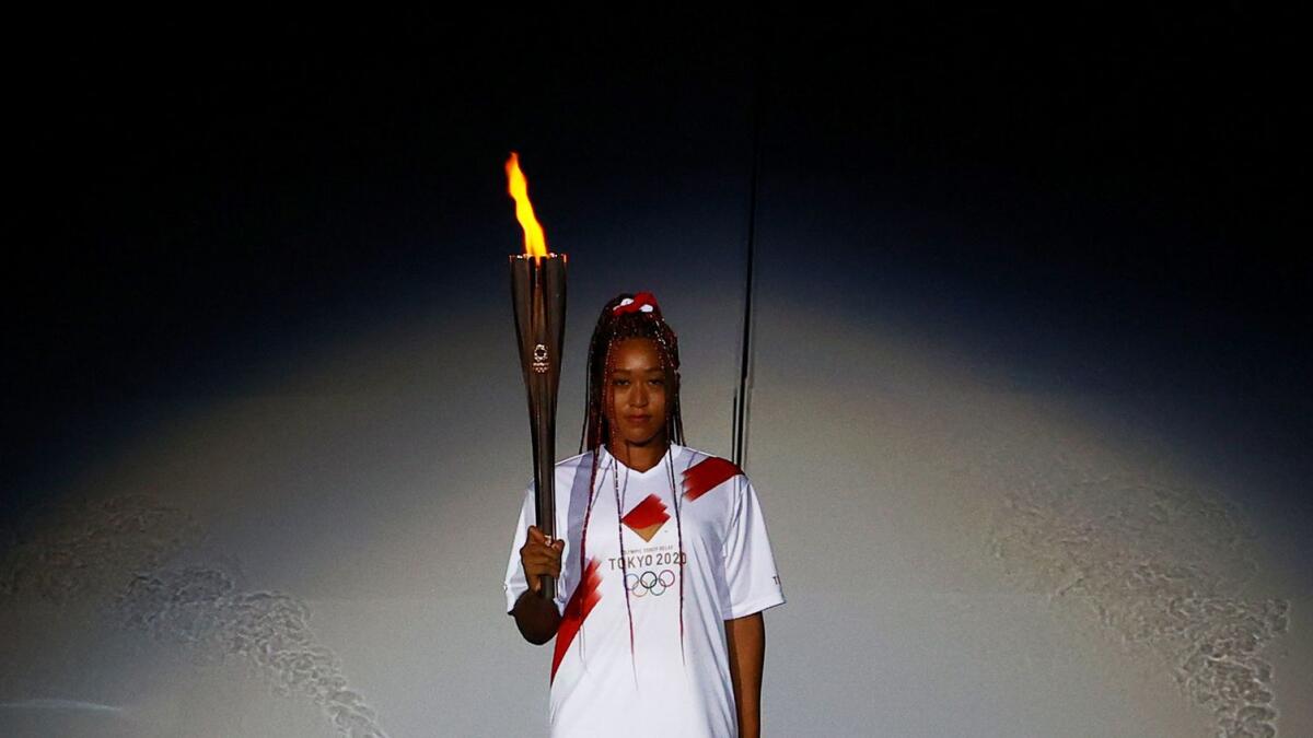Naomi Osaka of Japan holds the Olympic torch after lighting the Olympic cauldron at the opening ceremony. — Reuters