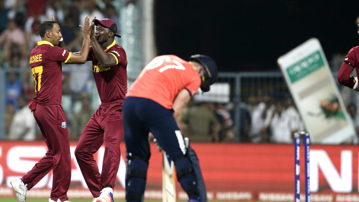 West Indies Samuel Badree, left, is congratulated by his captain Darren Sammy after bowling England's Jason Roy, right, during the final of the ICC World Twenty20 2016 cricket tournament at Eden Gardens in Kolkata, India.