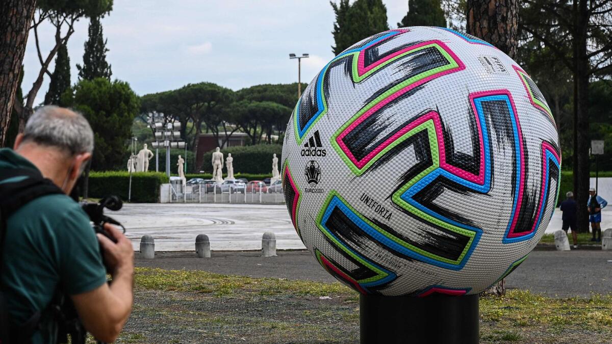 A video journalist films a giant football placed outside the Olympic Stadium in Rome, two days before the start of the Euro 2020. (AFP file)