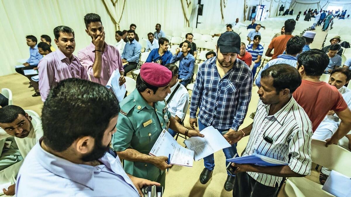 An officer assists amnesty-seekers at an immigration centre in  Dubai. — File photo
