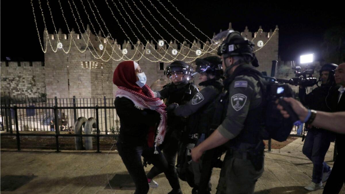 Israeli police scuffle with a Palestinian woman outside of the Damascus Gate to the Old City of Jerusalem. — AP