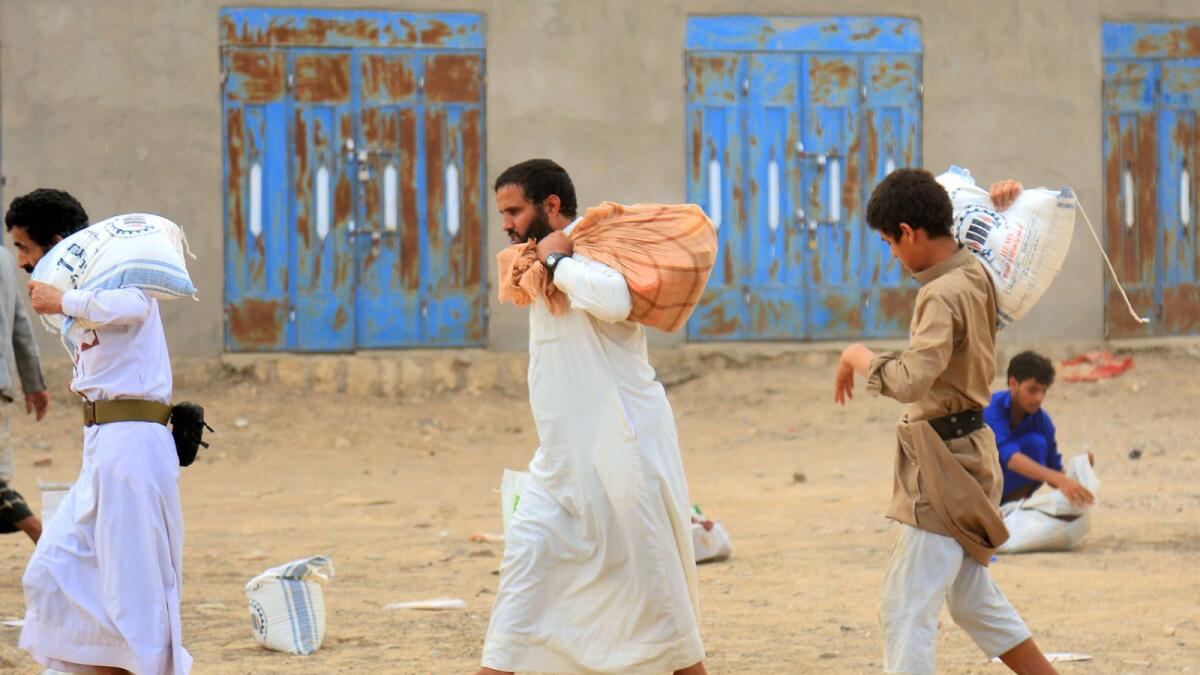 Yemeni men collect humanitarian aid provided by a Kuwaiti charitable organisation during a distribution to internally displaced people on the outskirts of the northeastern city of Marib. Photo used for illustrative purpose only. — AFP