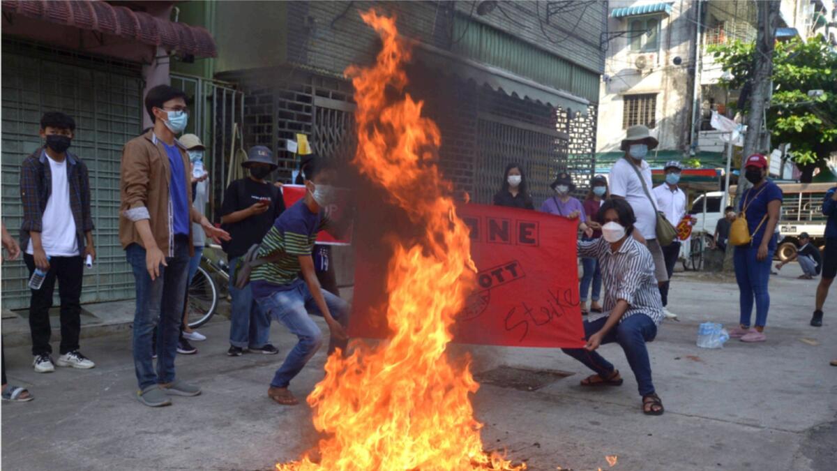 Anti-coup protesters burn a Chinese flag during a demonstration in Yangon. — AP