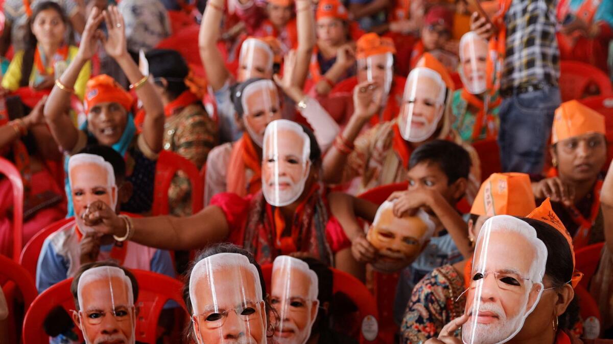Supporters of India's Prime Minister Narendra Modi wear masks of his face, as they attend an election campaign rally in Meerut. — Reuters