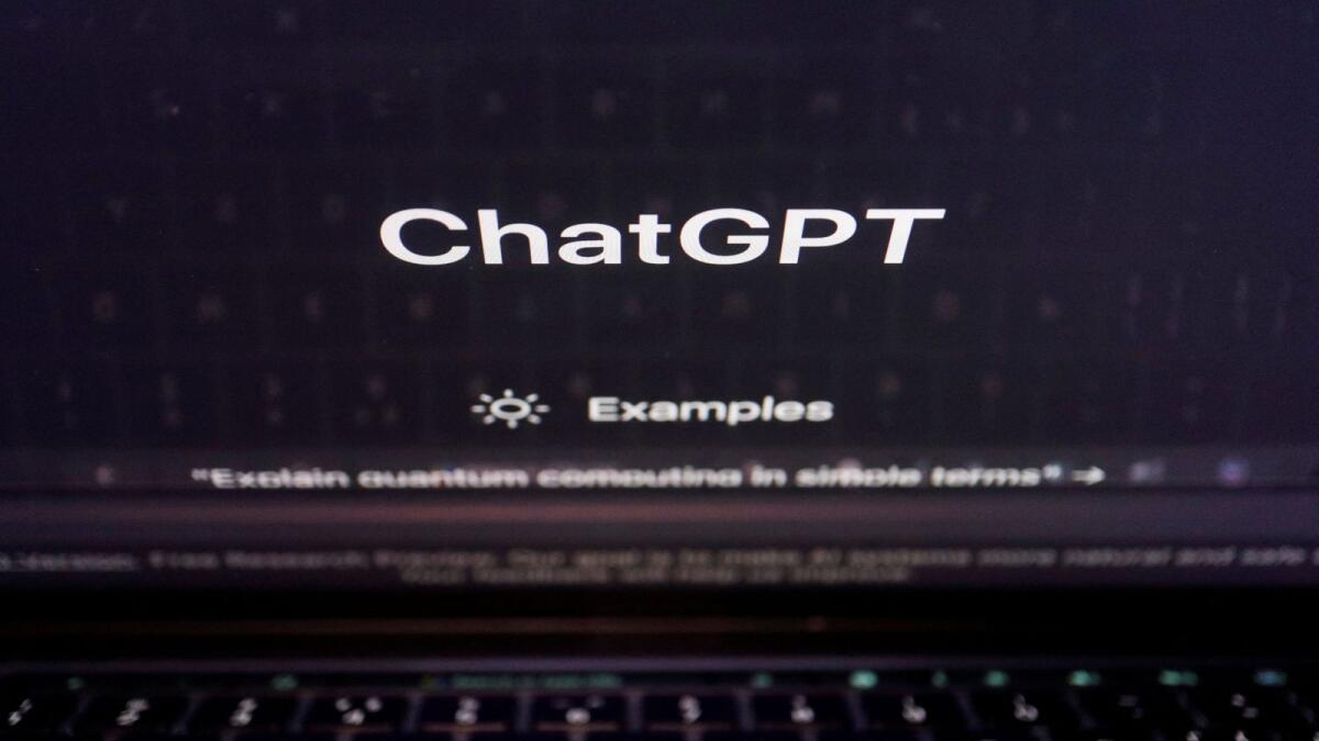 A keyboard is seen reflected on a computer screen displaying the website of ChatGPT. — Reuters