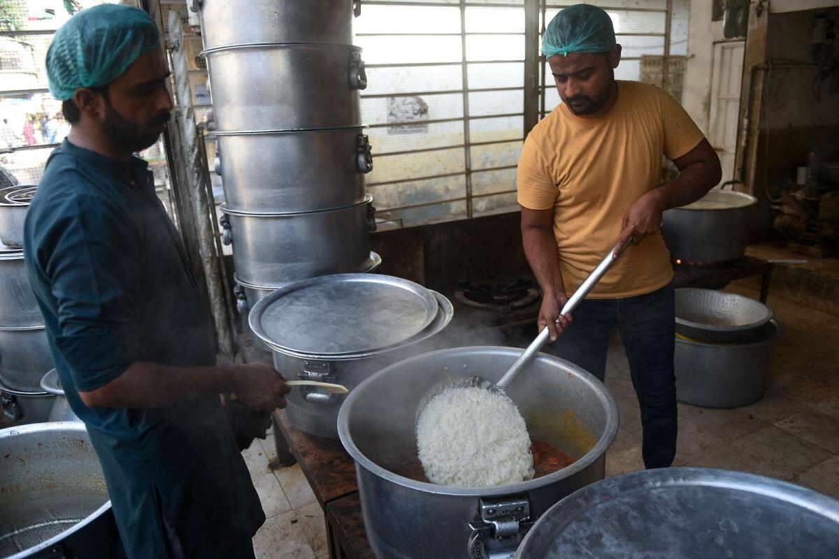 Staff cook biryani at a restaurant in Karachi.  — AFP