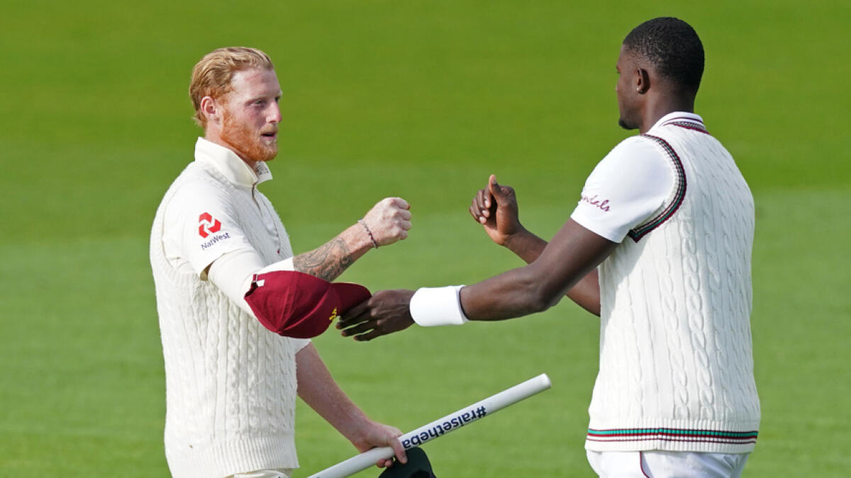 England's Ben Stokes (left) fist bumps with West Indies' Jason Holder after England won the second Test match on Monday. - AFP
