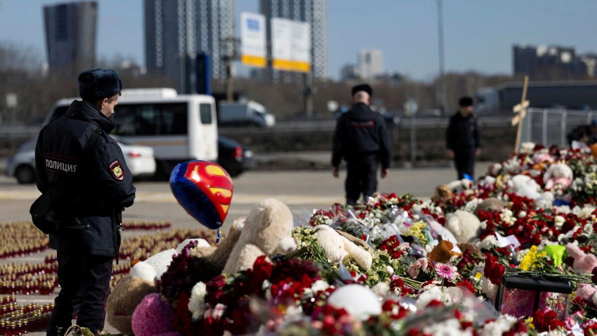 Police officers stand guard next to a makeshift memorial near the Crocus City Hall. — Reuters