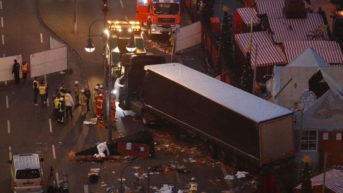 Forensic experts examine the scene around a truck that crashed into a Christmas market in Berlin.