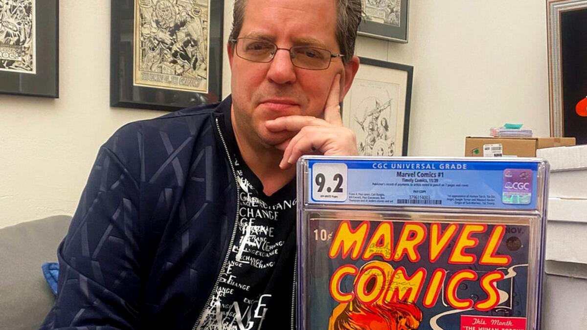 Stephen Fishler, co-owner and CEO of ComicConnect.com, poses for a photo holding up a copy of Marvel Comics #1. _ AP