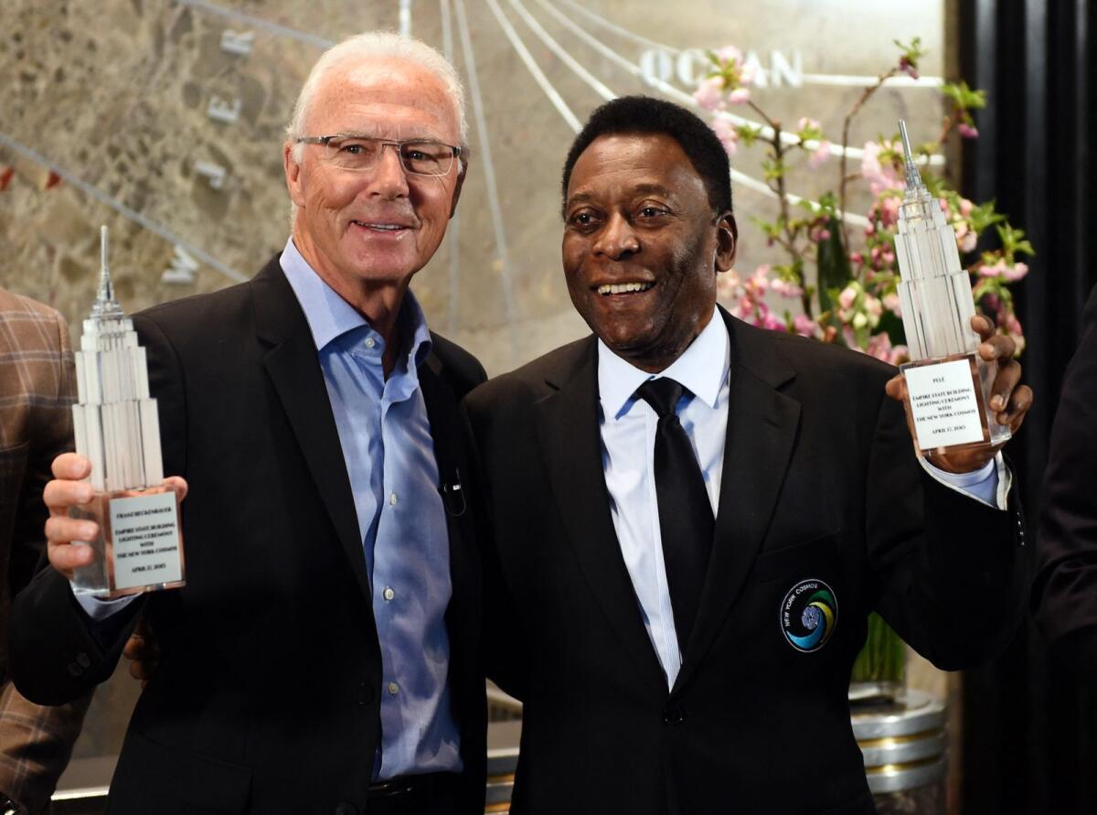 Brazil legend Pele (right) with Franz Beckenbauer. — AFP
