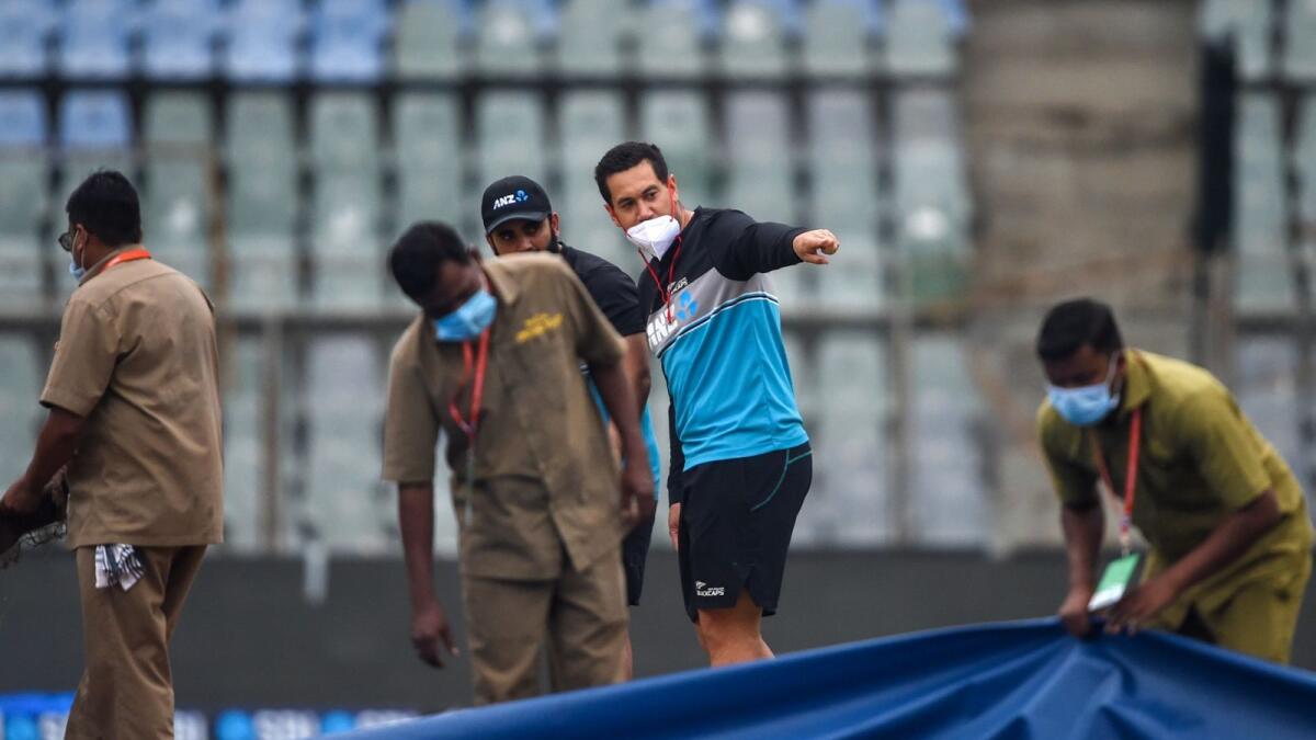 New Zealand's Ross Taylor (C) and Ajaz Patel inspect the pitch as ground staff remove the covers on the eve of the second Test cricket match against India at the Wankhede Stadium in Mumbai on December 2, 2021. (Photo by Punit PARANJPE / AFP) / IMAGE RESTRICTED TO EDITORIAL USE - STRICTLY NO COMMERCIAL USE - IMAGE RESTRICTED TO EDITORIAL USE - STRICTLY NO COMMERCIAL USE