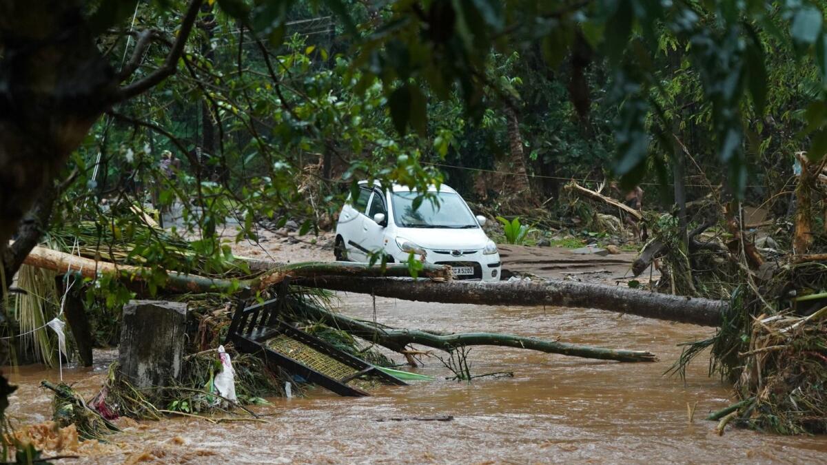 A car stucked in mud waters is pictured after floods caused by heavy rains in India's Kerala state. – AFP