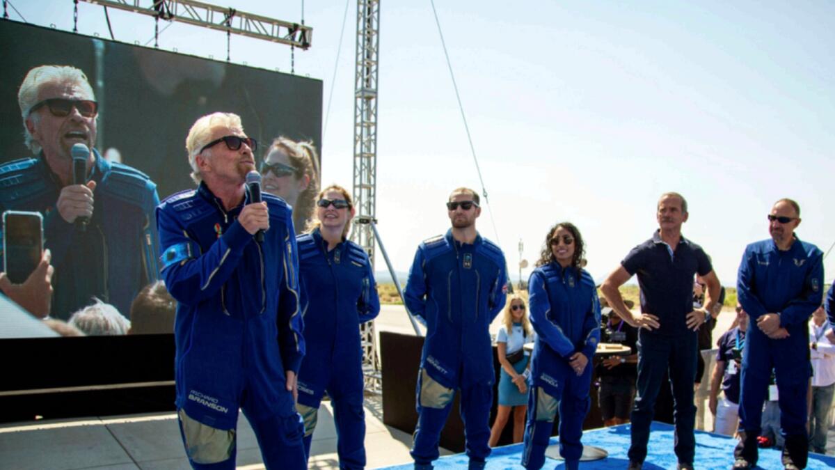 Virgin Galactic founder Richard Branson, accompanied by his crew, speaks to the crowd while celebrating their flight to space. — AP