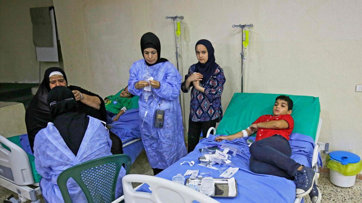 Patients infected in an outbreak of Vibrio cholera receive treatment in a mosque hall converted into a field hospital in the town of Bebnine in the Akkar district in north Lebanon on October 26, 2022.  — AFP