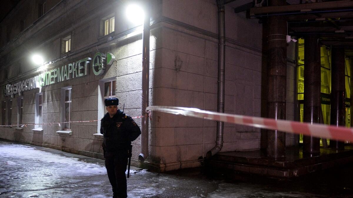 A police officer cordons off the site of a blast in a supermarket in Saint Petersburg.- AFP