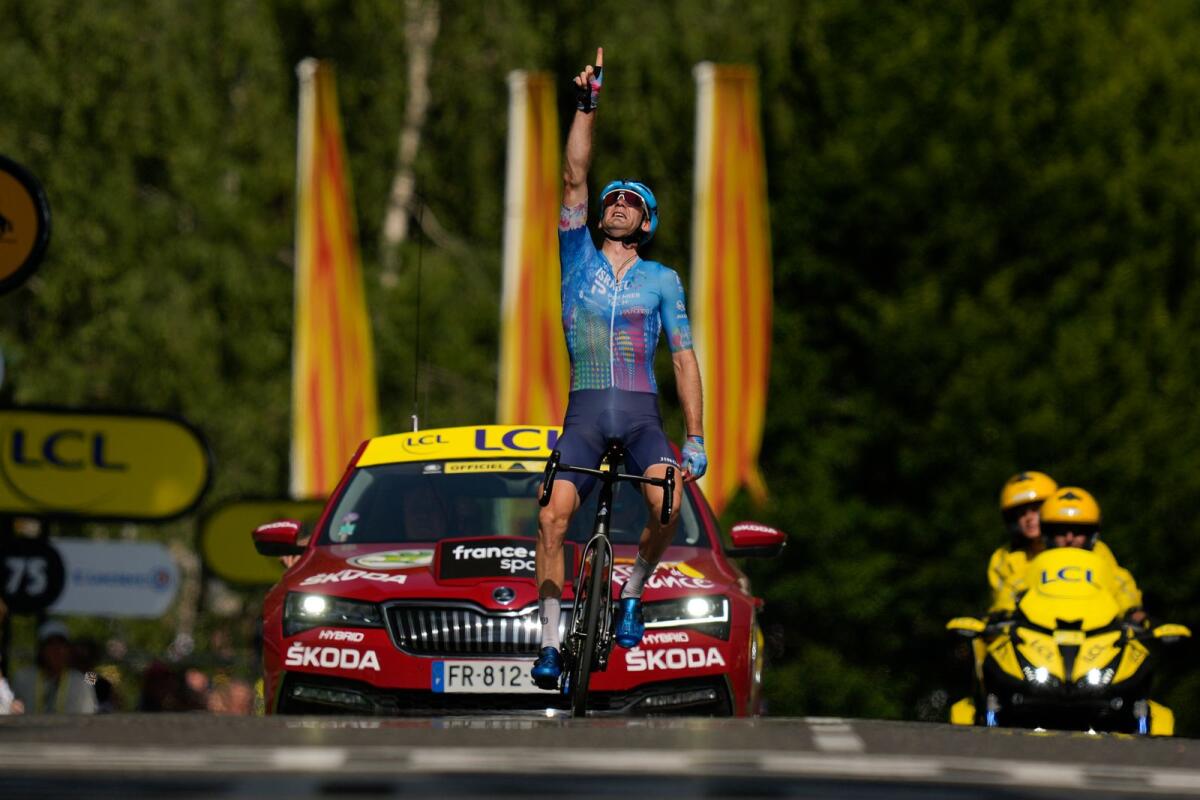Stage winner Canada’s Hugo Houle points to the sky and dedicates his victory to his brother Pierrick who was killed by a drunk driver almost 10 years ago. (AP)