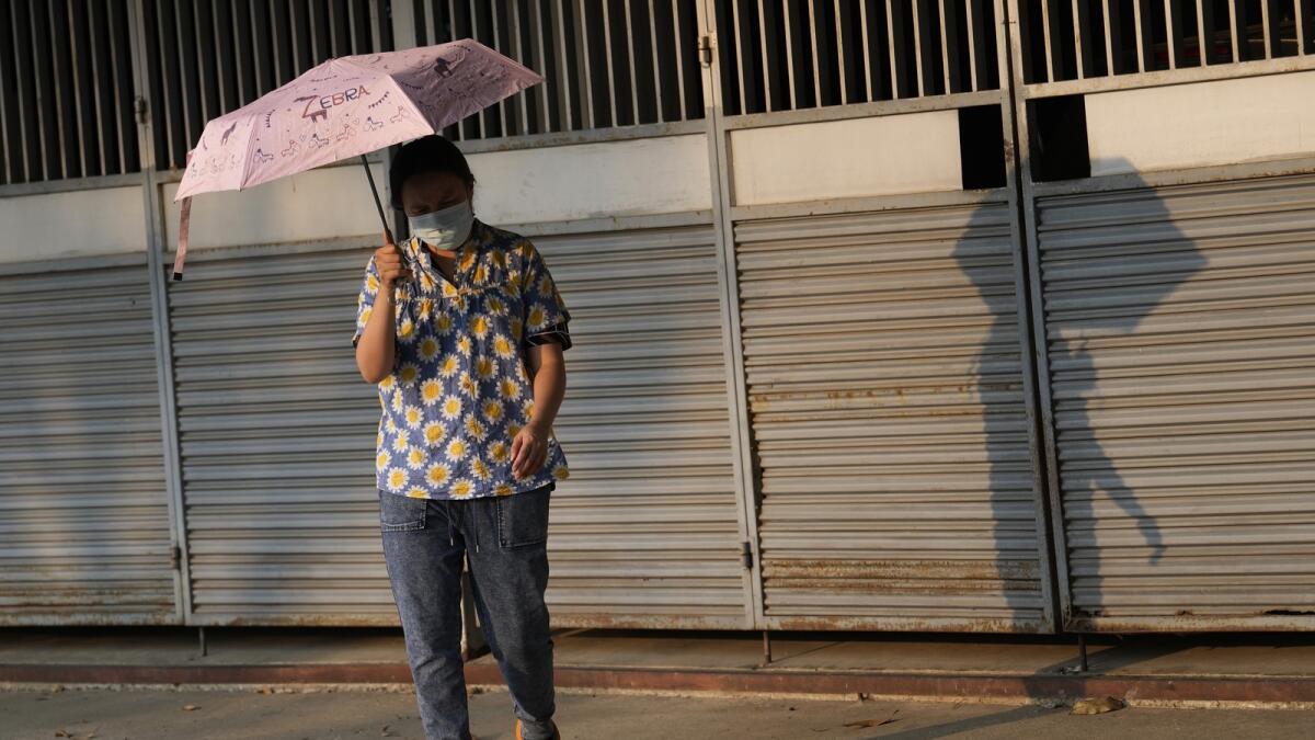A woman holds an umbrella to shelter from the sun in Bangkok, Thailand. — AP