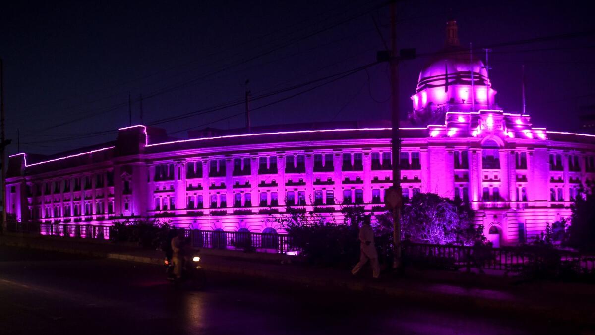 A building is lit with pink light on the occasion of the breast cancer awareness month in Karachi in October.